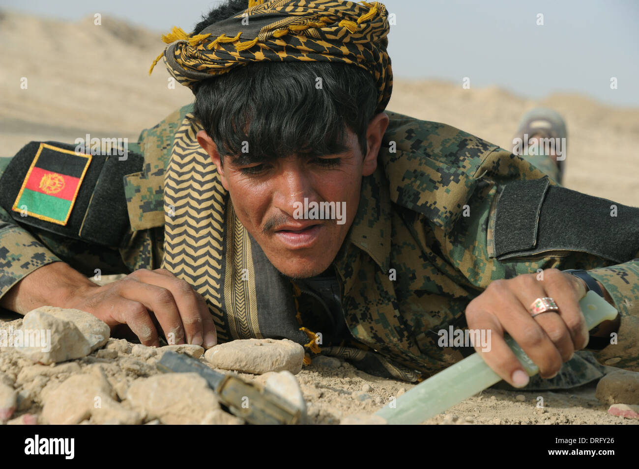 An Afghan Uniform Police officer practices searching for improvised explosive devices during training July 30, 2012 in the Deh Rawod, Uruzgan province, Afghanistan. Stock Photo