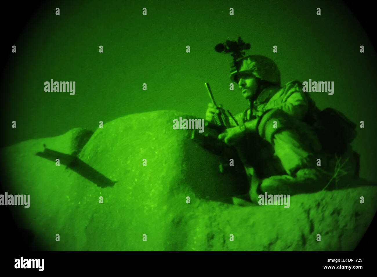 An Afghan National Army commando with the 5th Commando Kandak shown through night vision provides security from the roof of a compound during a village clearing operation July 4, 2012 in the Baghlan-e-Jadid district, Baghlan province, Afghanistan. Stock Photo