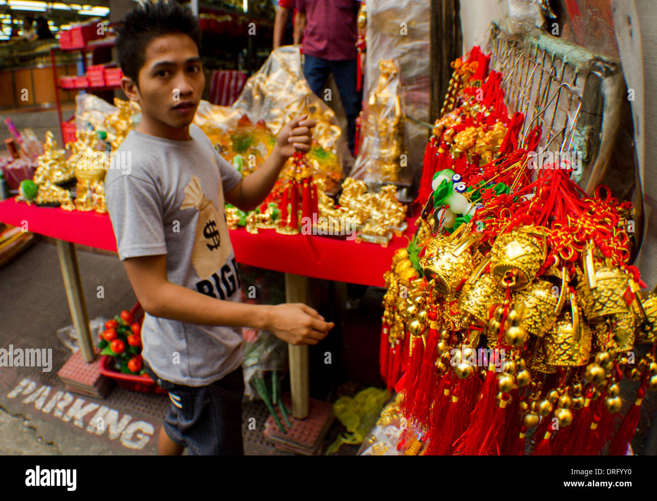 Metro Manila, Philippines-January 25, 2014: Street vendor preparing his display of lucky charms. A week before the annual celebration the Filipino-Chinese community prepares to welcome the Lunar New Year in Manila's Chinatown district, Binondo. Chinatown in Manila, considered to be the world’s oldest Chinatowns outside China. Credit:  Herman Lumanog/Alamy Live News Stock Photo