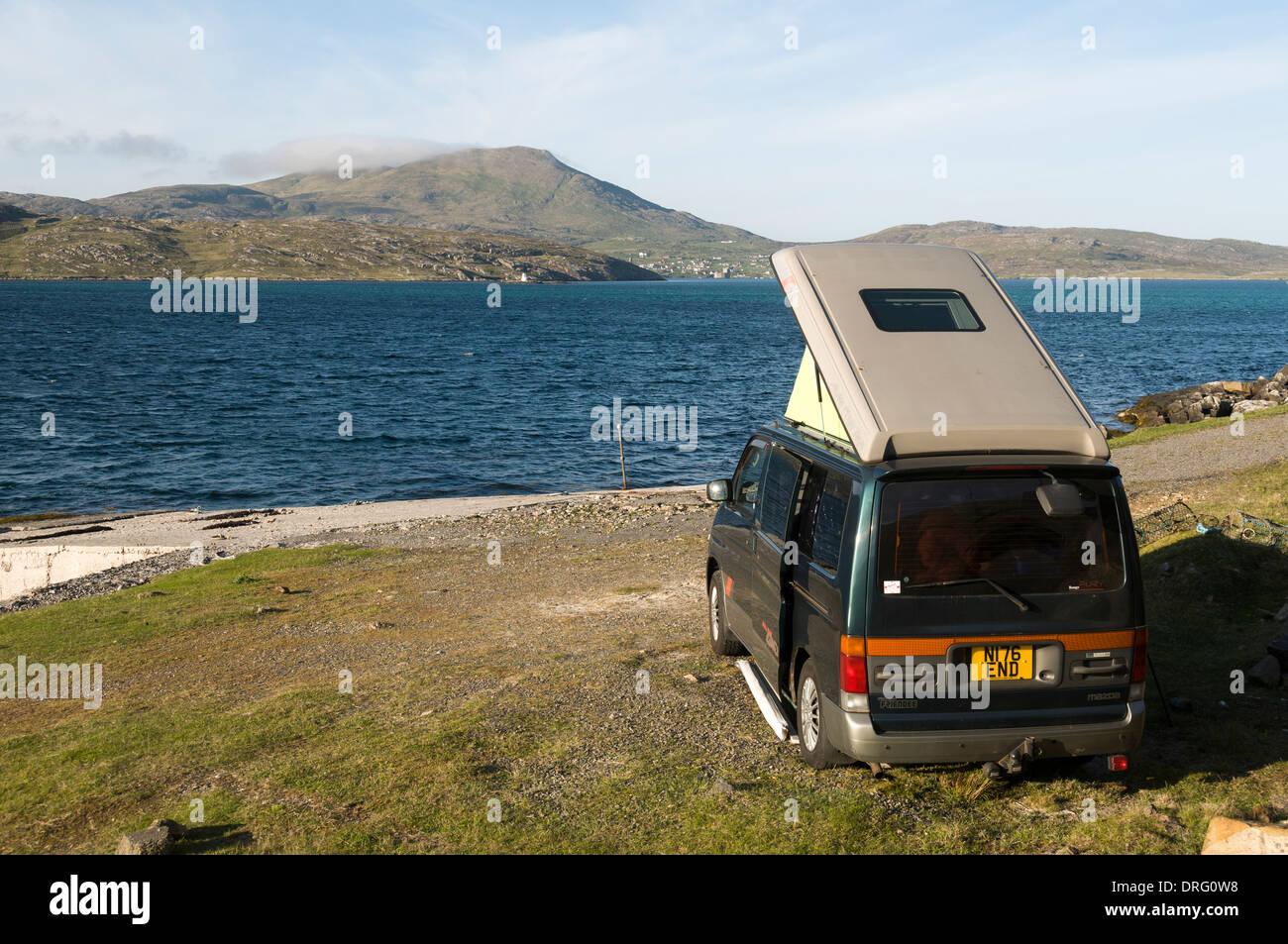 Mazda Bongo campervan on Vatersay looking over to Castlebay and Heaval on the Isle of Barra, Outer Hebrides, Scotland, UK Stock Photo