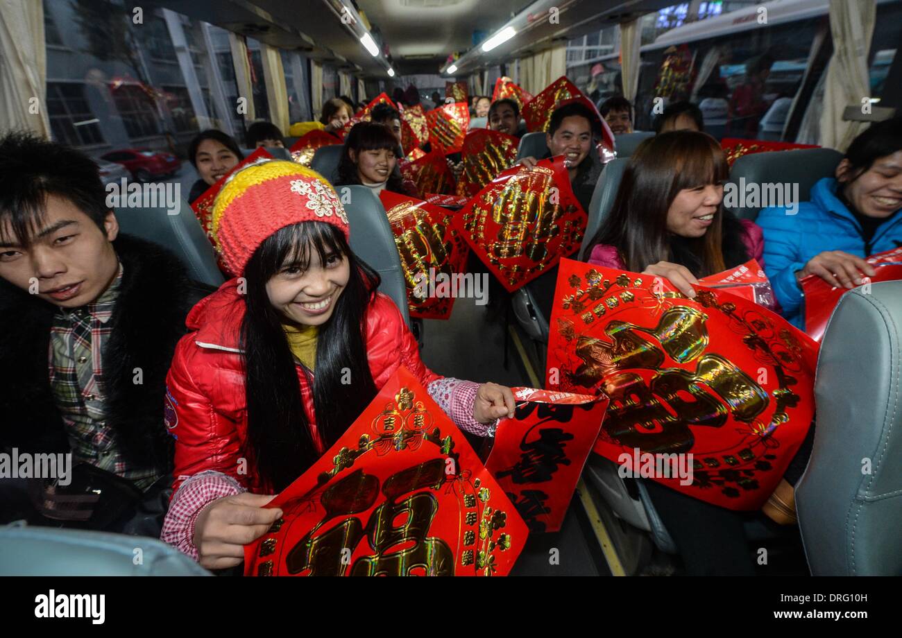 Anji, China's Zhejiang Province. 25th Jan, 2014. Workers of Henglin Chair Industry, a local private company, show the Chinese couplets on a chartered bus for home in Anji County, east China's Zhejiang Province, Jan. 25, 2014. Henglin chartered 20 buses to send its workers home for free for family reunion prior to the Spring Festival, which falls on Jan. 31 this year. © Xu Yu/Xinhua/Alamy Live News Stock Photo