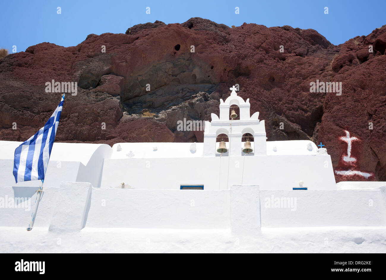 Traditional church with Greece flag in red beach, Santorini Stock Photo
