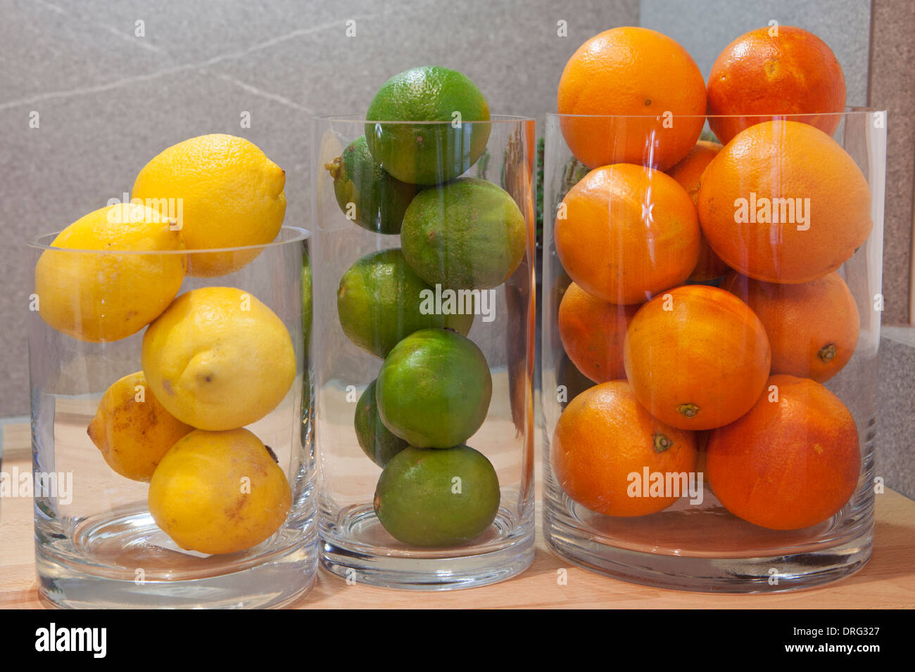 Glass vases with different fruits lemons, limes, oranges Stock Photo