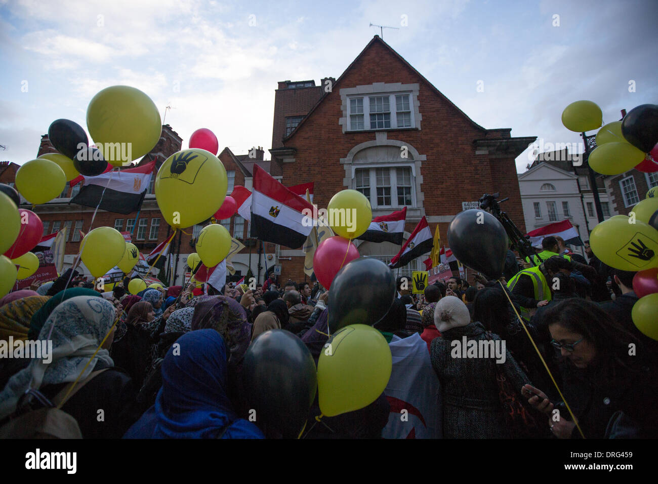 London, UK. 25th January 2014.  Protesters with balloons and banners chant pro Morsi slogans and dance in front of the Egyptian Embassy in London. Credit:  Lydia Pagoni/Alamy Live News Stock Photo
