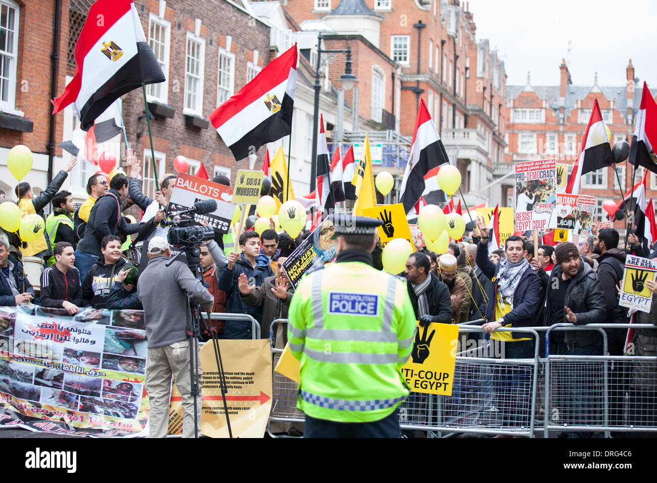 London, UK. 25th January 2014.  Protesters with banners chant pro Morsi slogans and dance in front of the Egyptian Embassy in London. Credit:  Lydia Pagoni/Alamy Live News Stock Photo