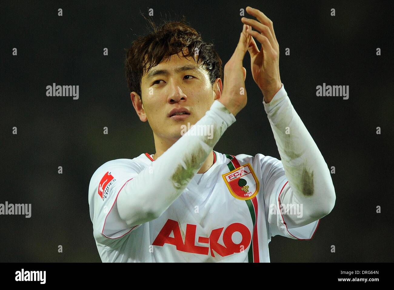 Dortmund, Germany. 25th Jan, 2014. Augsburg's Ji Dong Won applauds supporters after the soccer Bundesliga match between Borussia Dortmund and FC Augsburg at the SignalIdunaPark in Dortmund, Germany, 25 January 2014. Photo: MARIUS BECKER (ATTENTION: Due to the accreditation guidelines, the DFL only permits the publication and utilisation of up to 15 pictures per match on the internet and in online media during the match.)/dpa/Alamy Live News Stock Photo