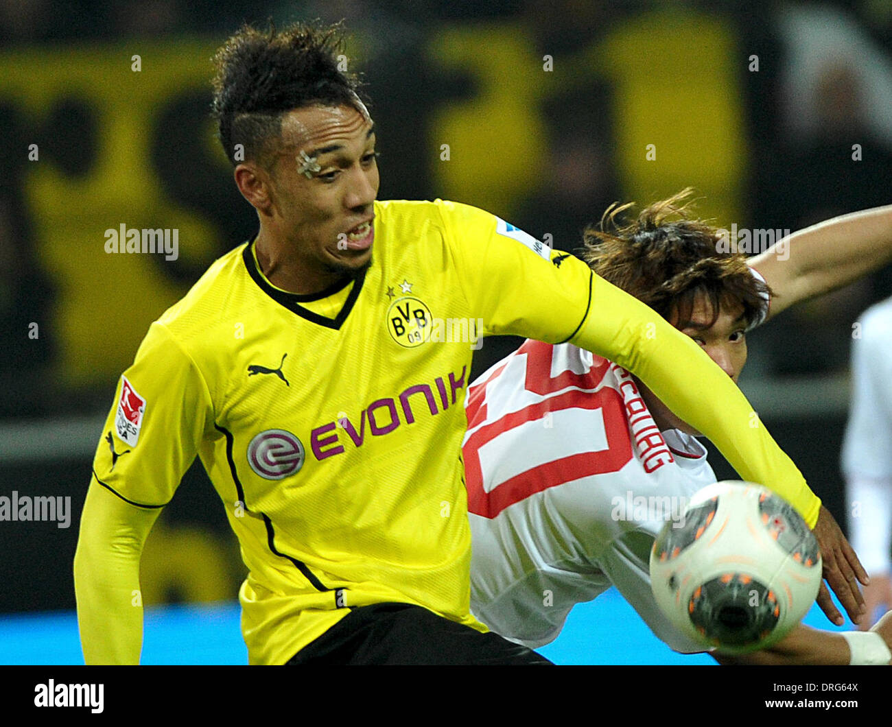 Dortmund, Germany. 25th Jan, 2014. Dortmund's Pierre-Emerick Aubameyang (L) and Augsburg's Jeong-Ho Hong vie for the ball during the German Bundesliga soccer match between Borussia Dortmund and FC Augsburg at the SignalIdunaPark in Dortmund, Germany, 25 January 2014. Photo: JAN-PHILIPP STROBEL (ATTENTION: Due to the accreditation guidelines, the DFL only permits the publication and utilisation of up to 15 pictures per match on the internet and in online media during the match.)/dpa/Alamy Live News Stock Photo