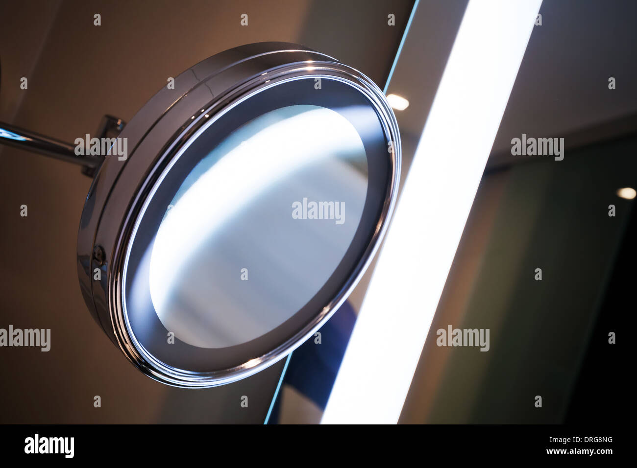 Round mirror with bright illumination in the bathroom Stock Photo