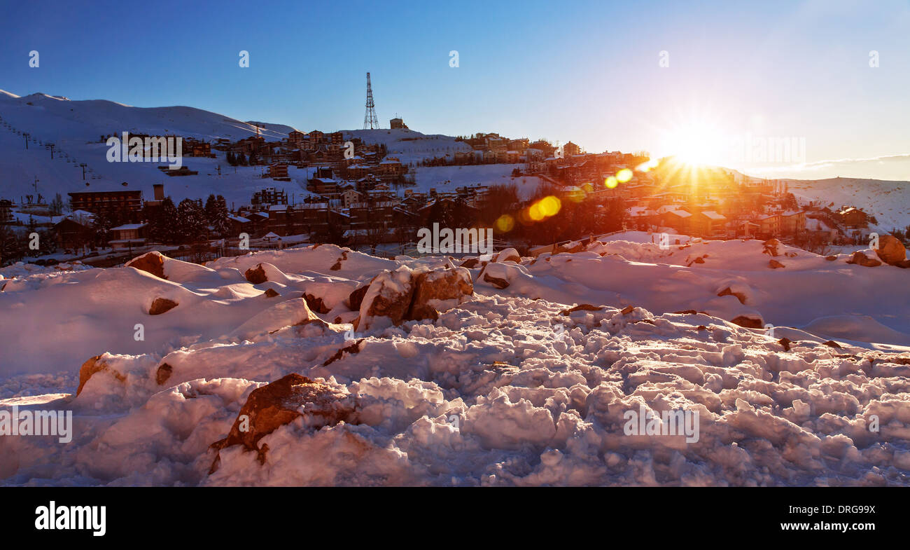 Mountainous village in sunset in wintertime, snowy hills, fresh air, scene destination, beautiful winter nature, cold weather Stock Photo