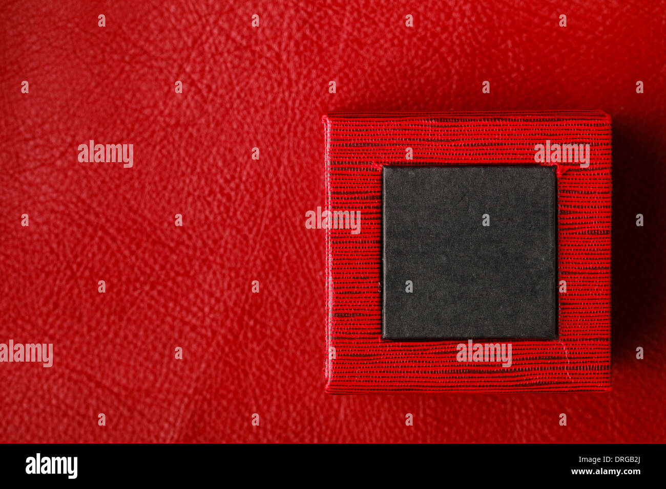 Red black rectangular ring jewellery box on leather background Stock Photo