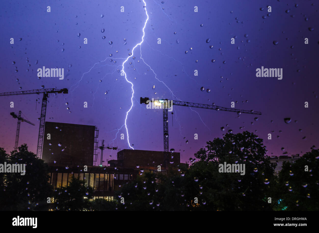 Lightning strike in a construction area viewed through glass with rain drops Stock Photo Alamy