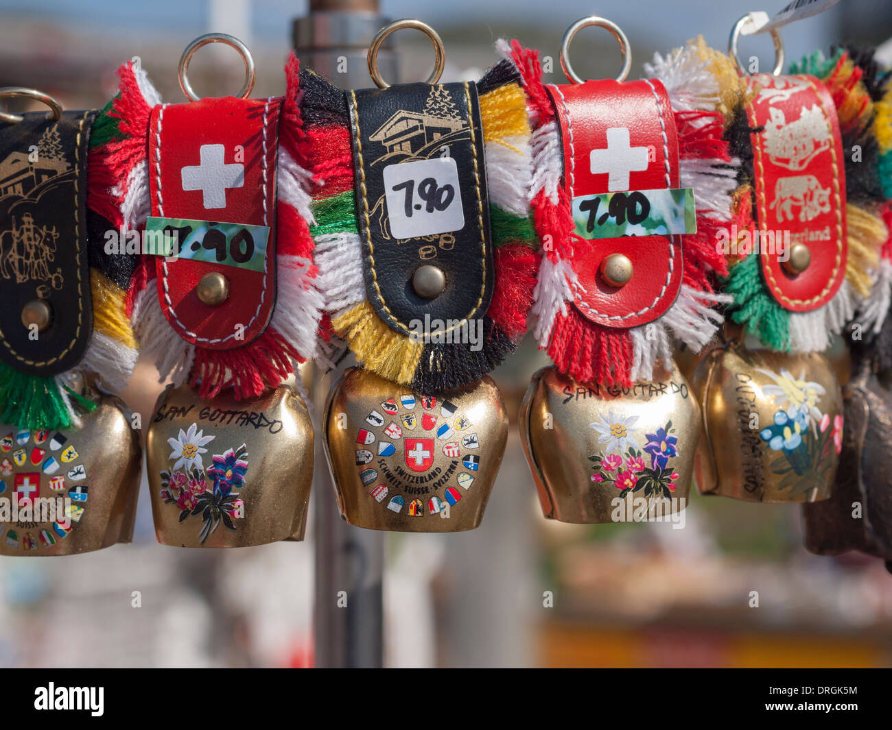 Miniatures of Swiss cowbell-keyrings for sale as tourist souvenir at the top of the Swiss mountain pass 'San Gottardo'. Stock Photo