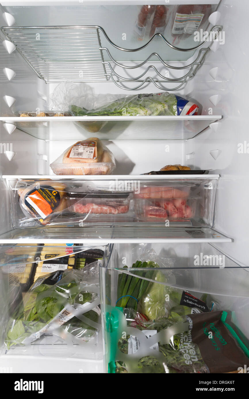 Inside view of a fridge containing meat,poultry,herbs,vegetables and salad items Stock Photo