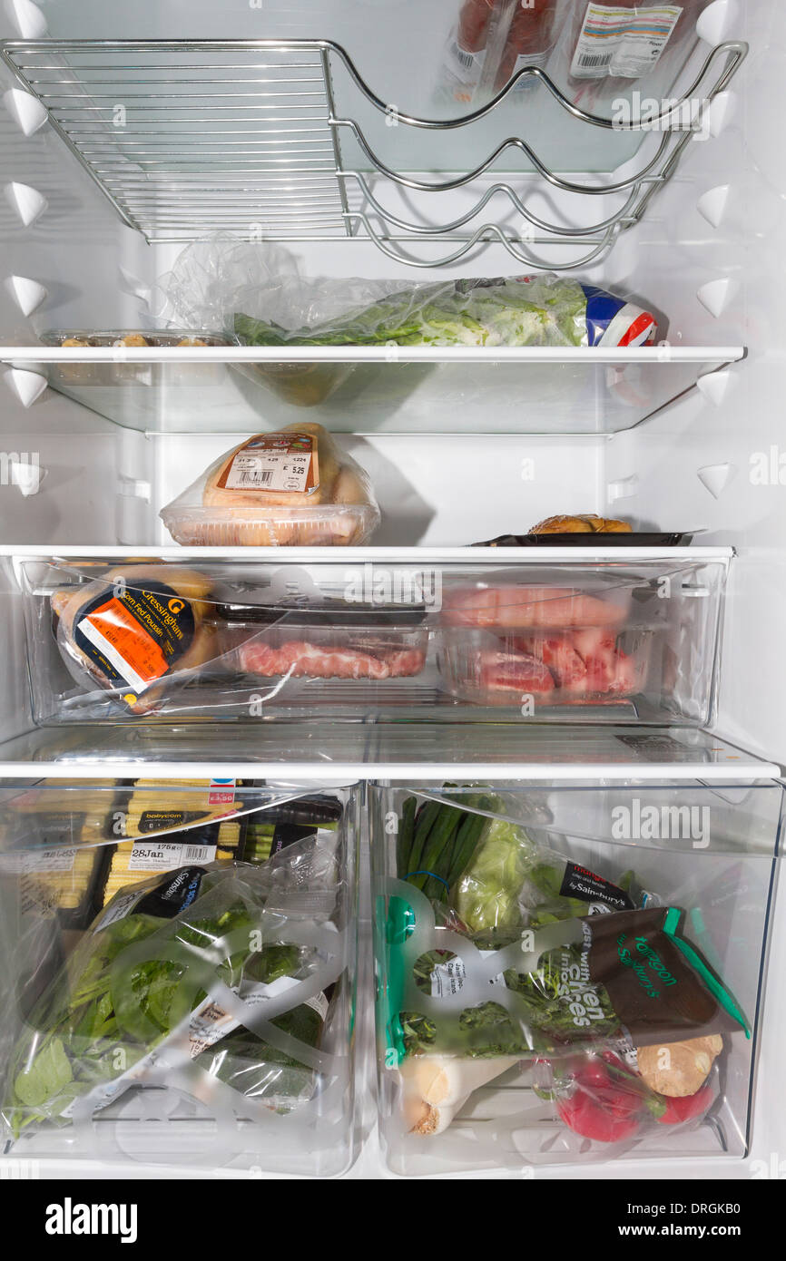 Inside view of a fridge containing meat,poultry,herbs,vegetables and salad items Stock Photo