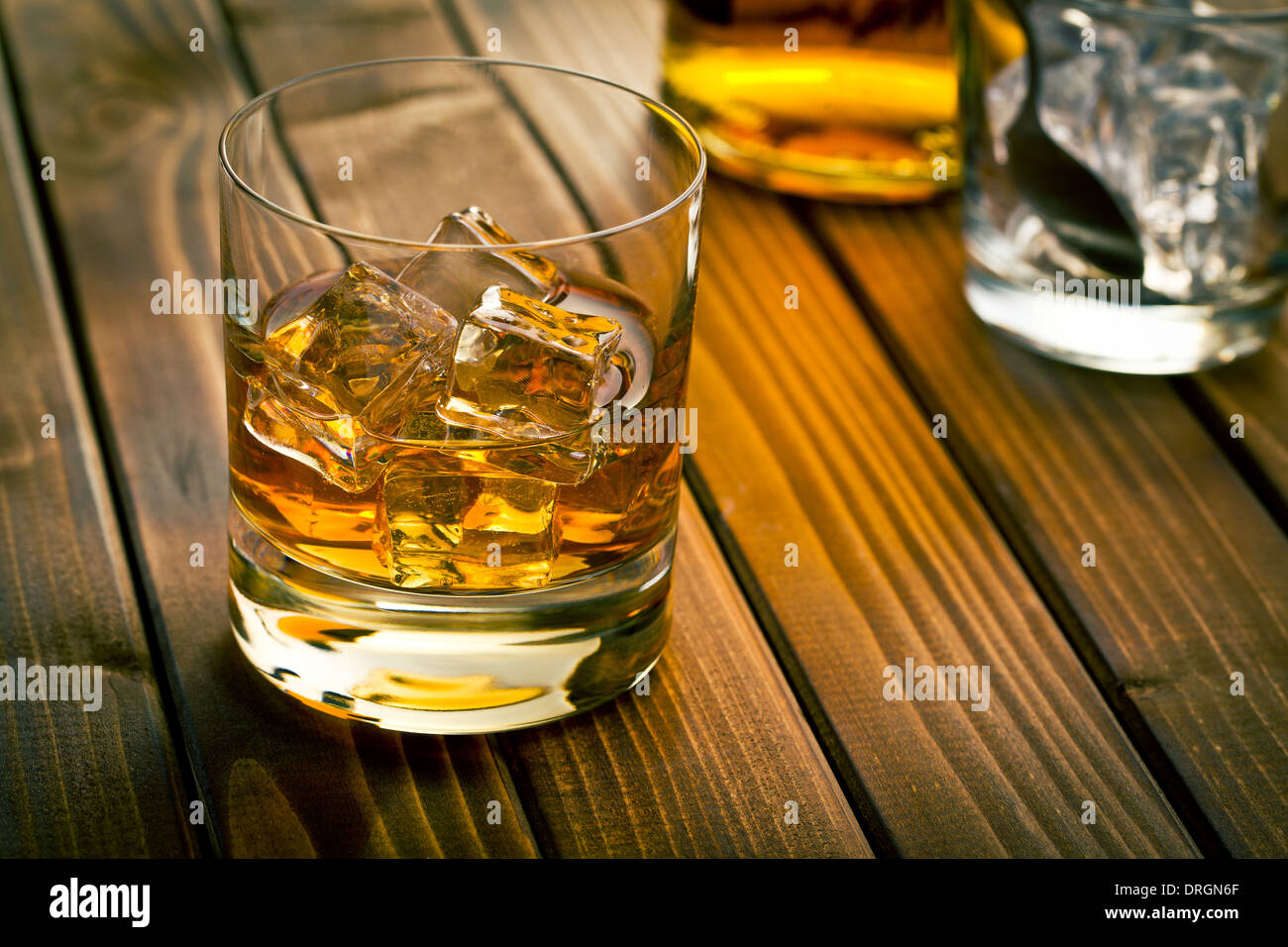 whiskey in glass with ice on wooden table Stock Photo