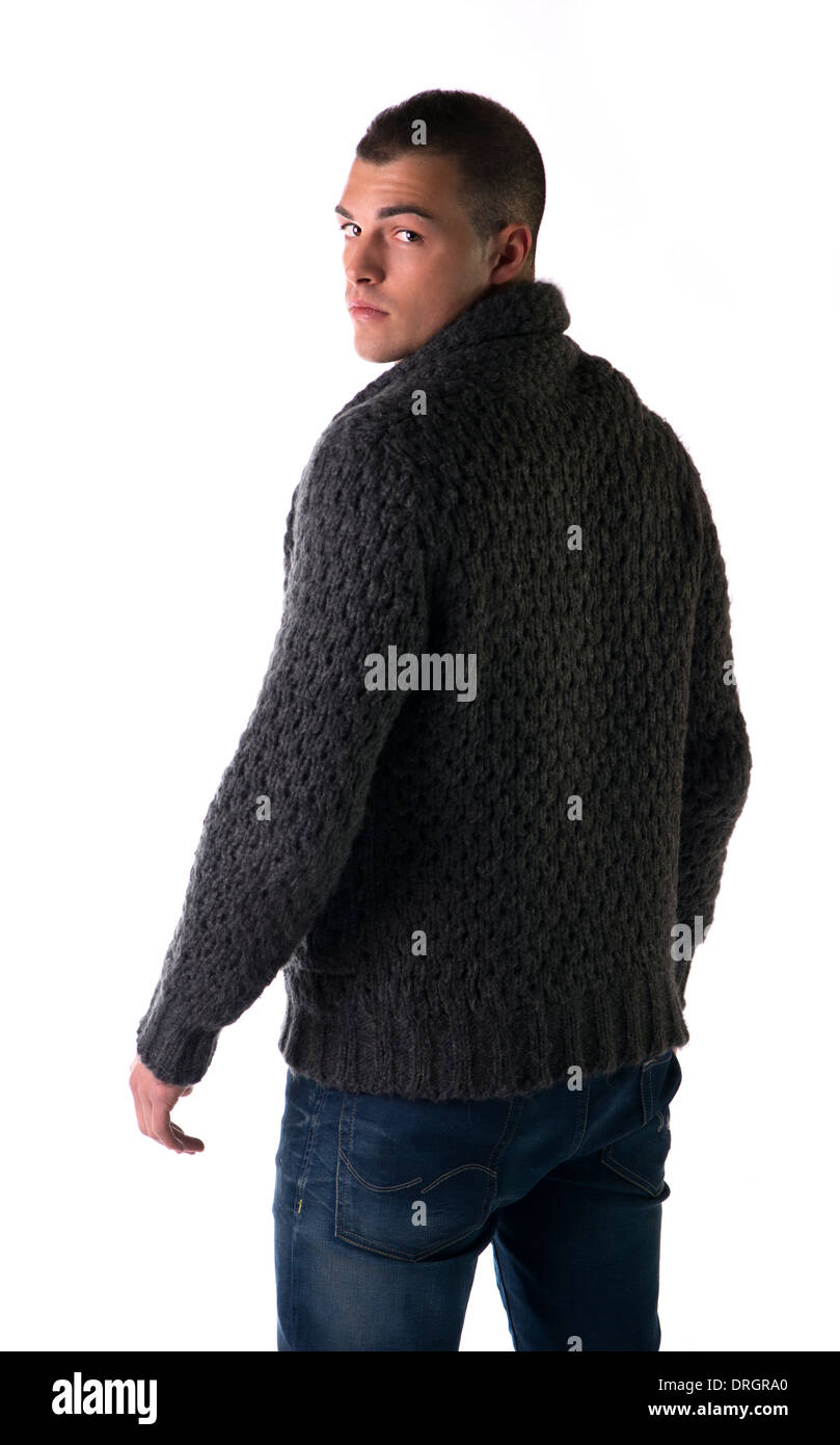 Attractive young man with wool sweater and jeans seen from the back, isolated on white background Stock Photo