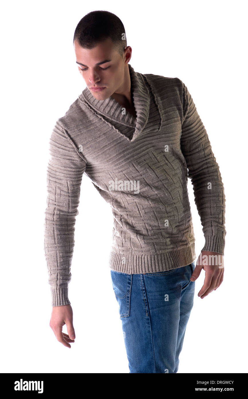 Attractive young man with wool sweater and jeans, isolated on white background, looking down Stock Photo