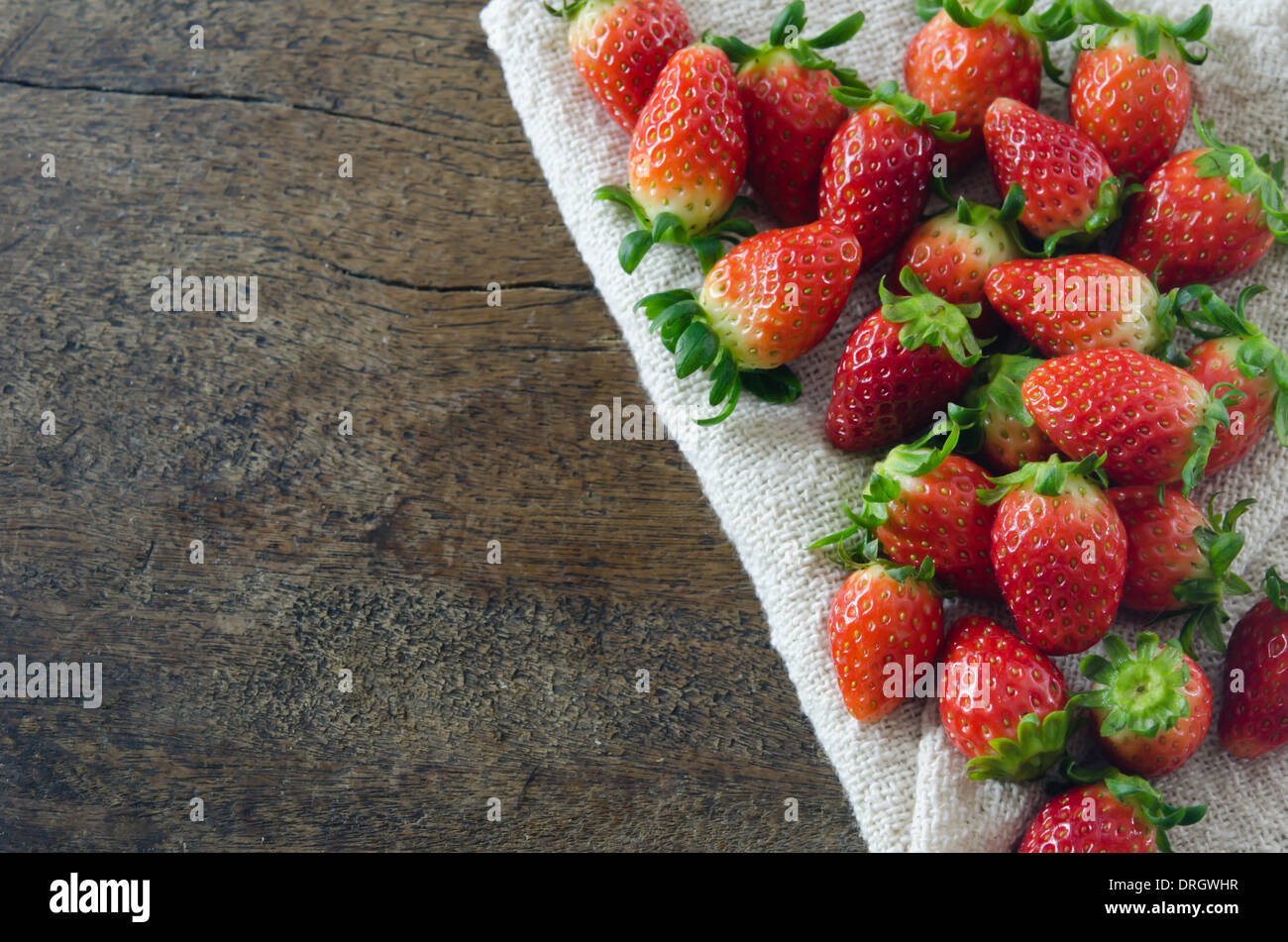 still life of fresh red strawberries on sackcloth over wooden ...
