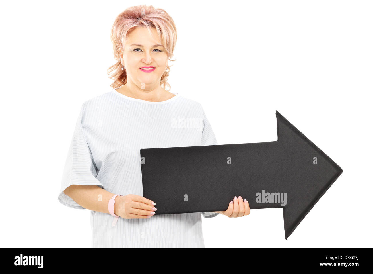 Female patient in hospital gown holding big black arrow pointing right ...