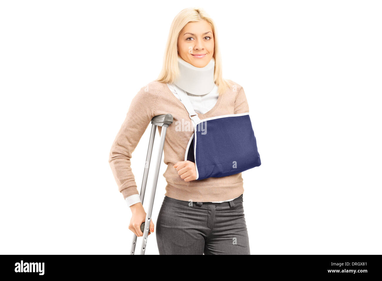 Happy blond female with broken arm holding a crutch posing Stock Photo