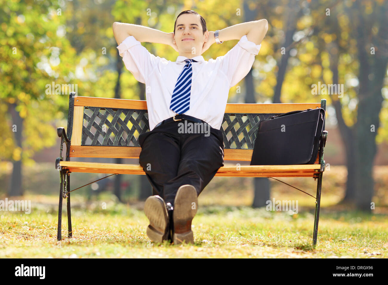 Business man sitting on bench in park hi-res stock photography and ...