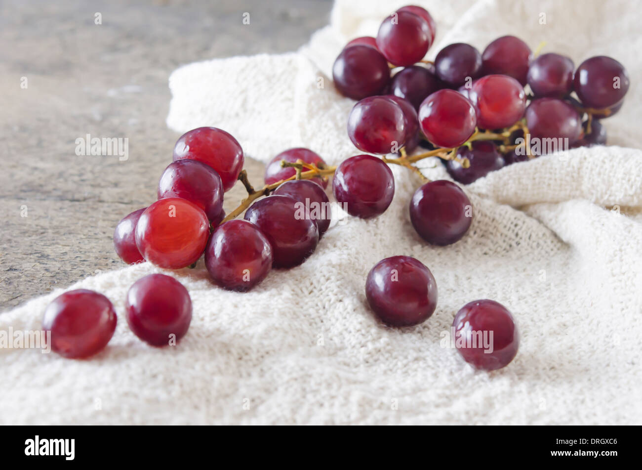 red grape on sackcloth over wooden background Stock Photo