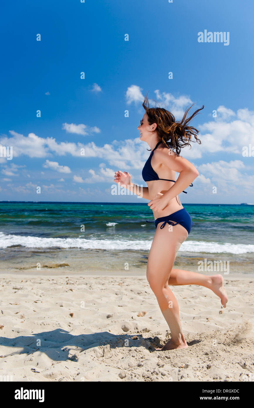 Frau im Bikini beim Joggen am Strand, Ibiza, Spanien - woman jogging at the beach, Ibiza, Spain Stock Photo