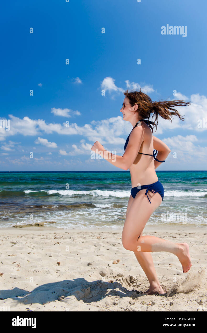 Frau im Bikini beim Joggen am Strand, Ibiza, Spanien - woman jogging at the beach, Ibiza, Spain Stock Photo