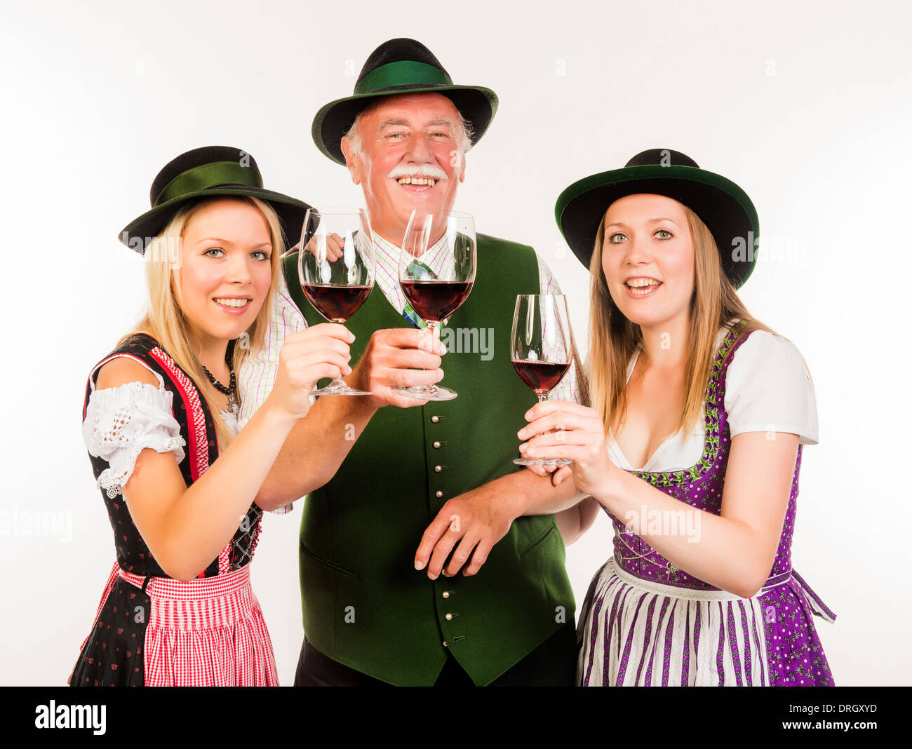 Senior und zwei junge Frauen in Tracht mit Weingläsern - people in traditional costume with wine glasses Stock Photo