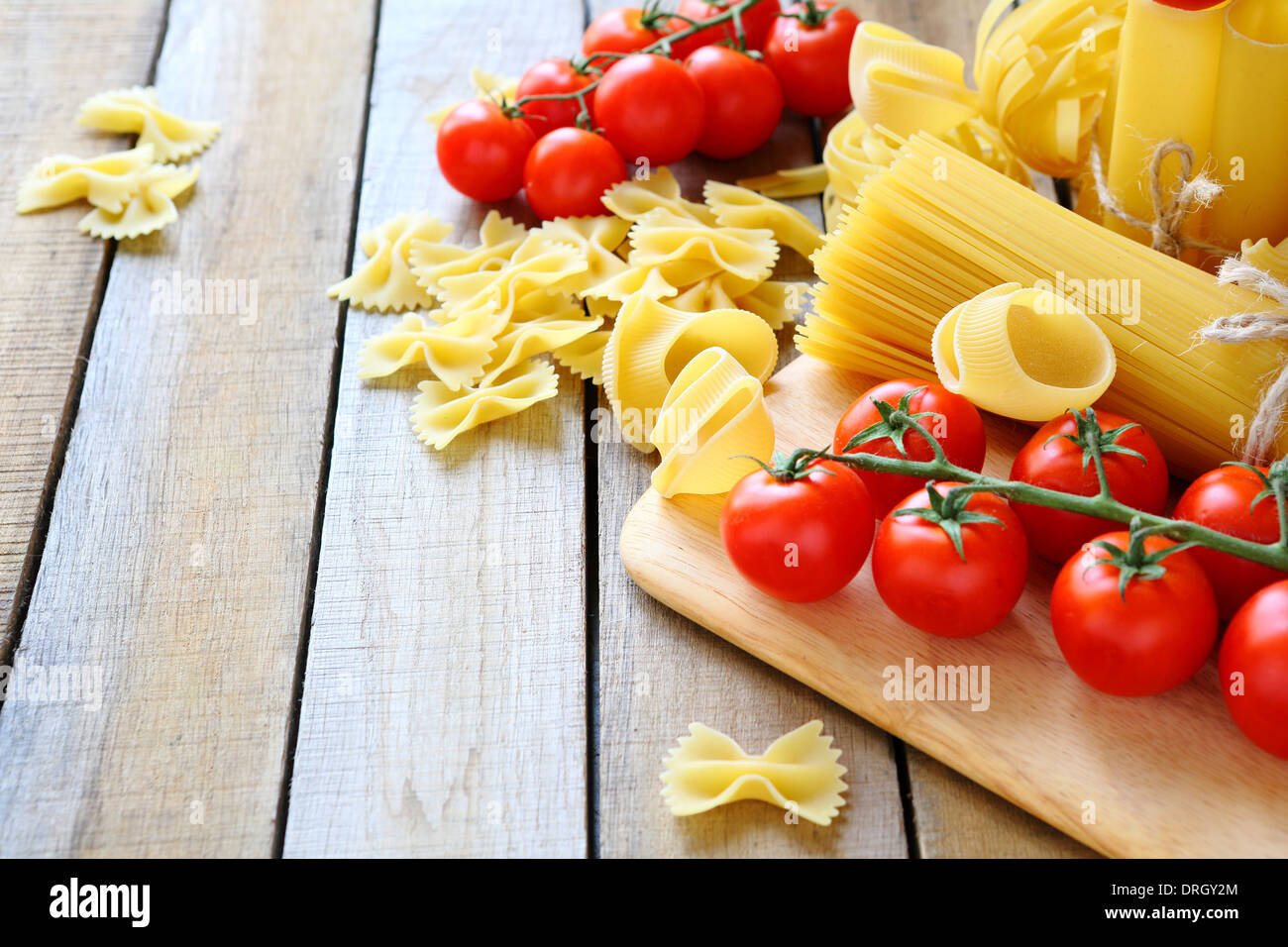 uncooked pasta and cherry tomatoes branch, food closeup Stock Photo