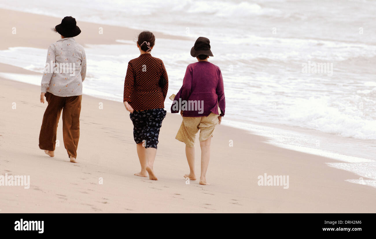 Three mature Vietnamese Asian women ladies walking on a beach by the ...