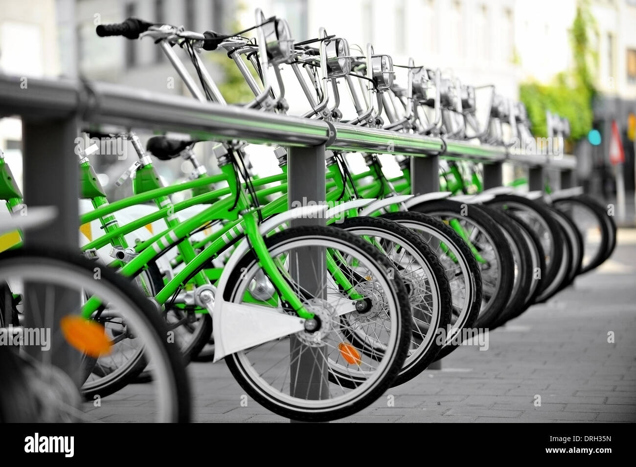 Urban scene with green bicycles for rent in a velo station Stock Photo