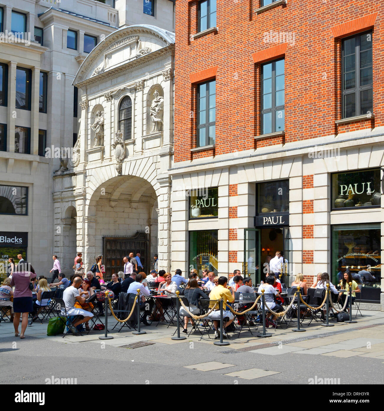 Diners outdoors at the Paul restaurant in St Pauls Churchyard beside Temple Bar Gate Stock Photo