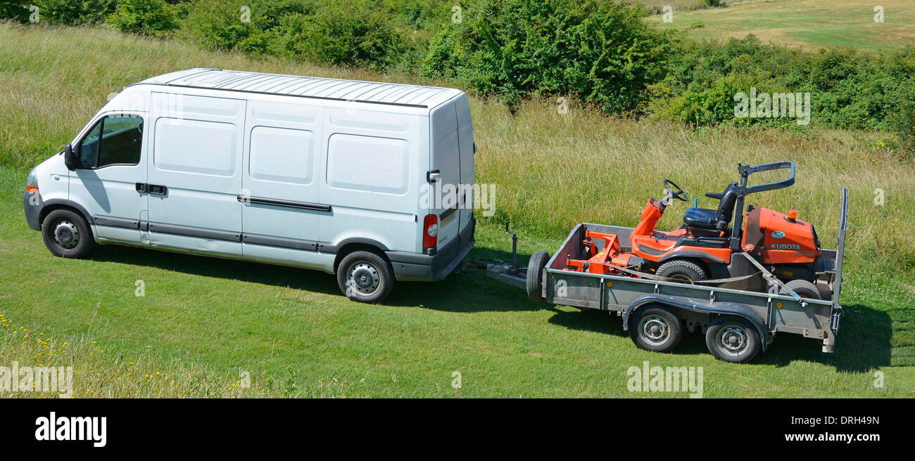 White van towing trailer with sit on grass mower in country park Stock Photo Alamy