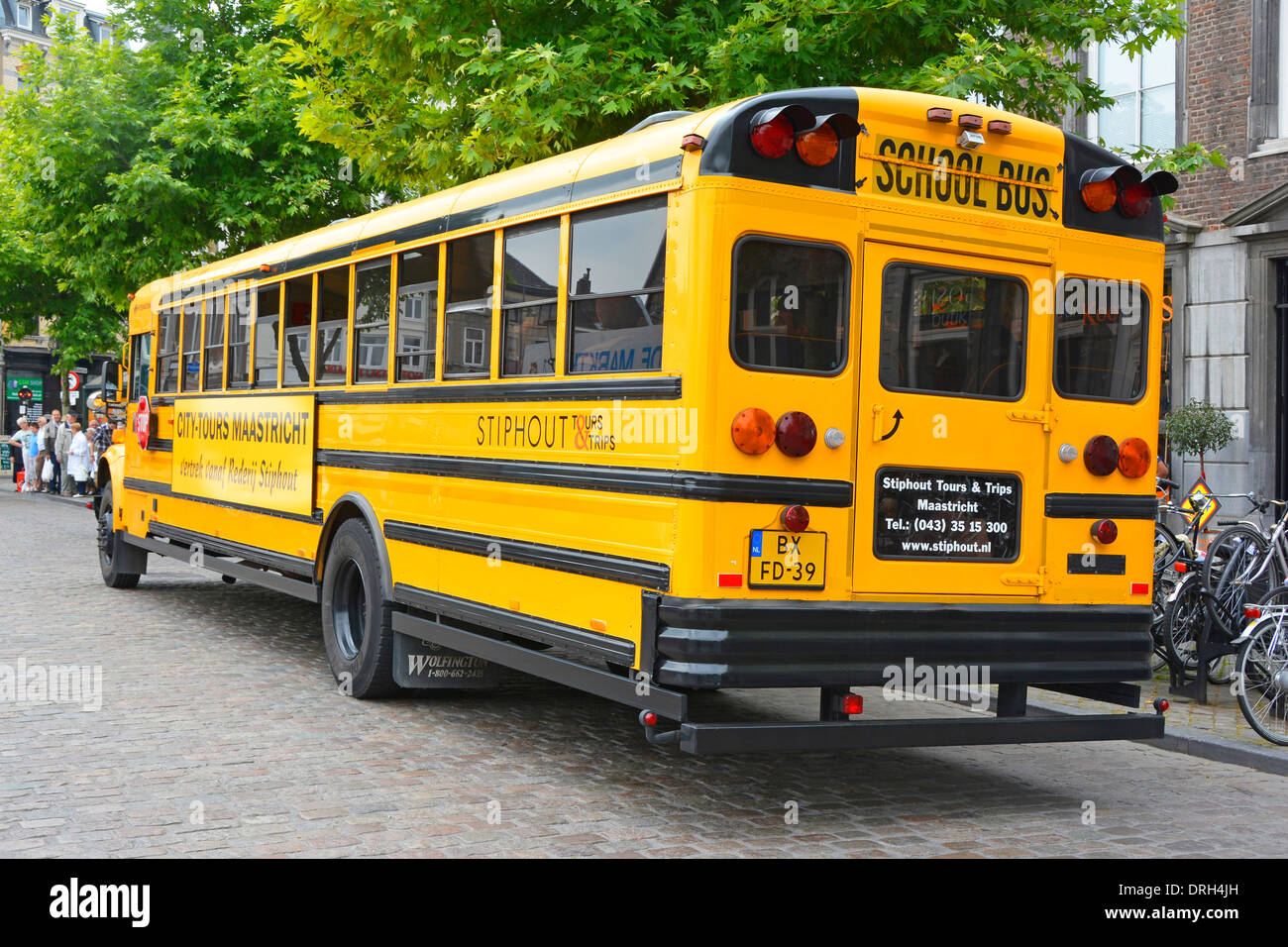 Yellow American school bus adapted for city sightseeing tours of Maastricht Limburg Netherlands Holland Stock Photo