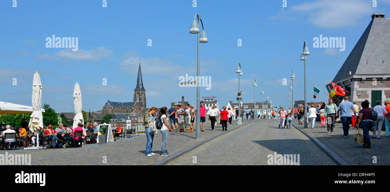 City of Maastricht people on Saint Servatius (Sint Servaasbrug) bridge over the river Meuse on a hot sunny summers July blue sky day Netherlands EU Stock Photo
