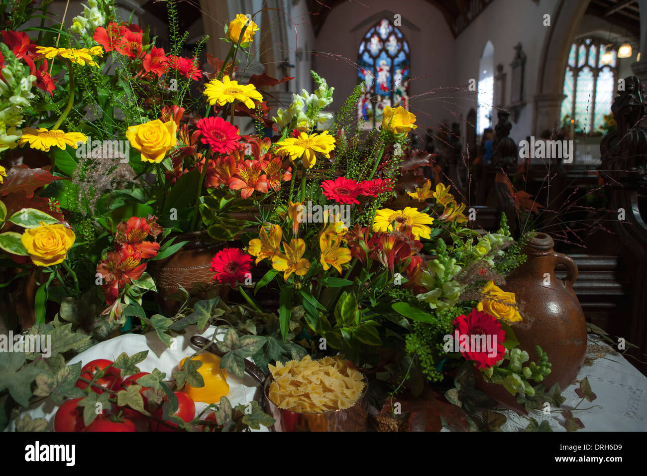 Italian themed flower arrangement in English country church at Harvest festival Stock Photo