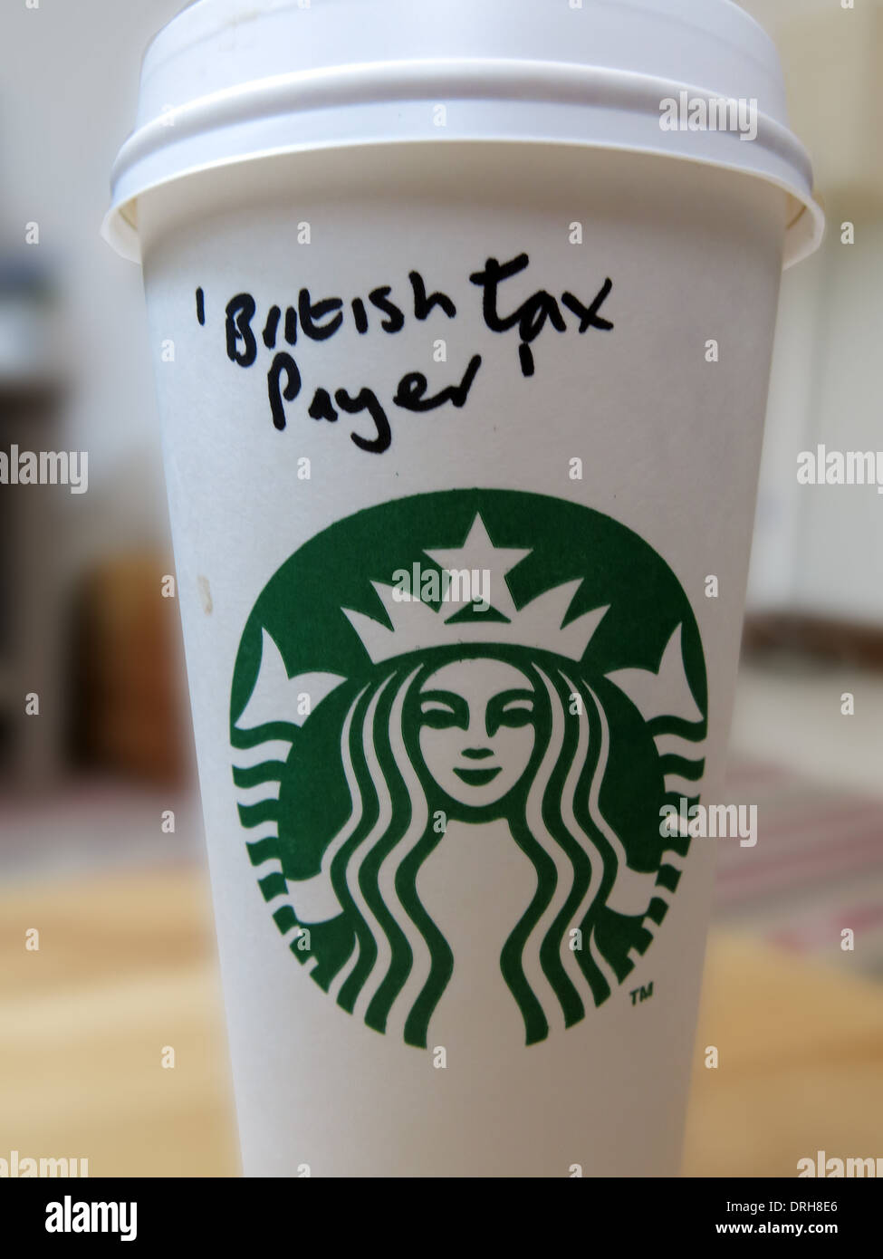 Starbucks coffee cup with British Tax Payer as name. Someone expressing anger Stock Photo
