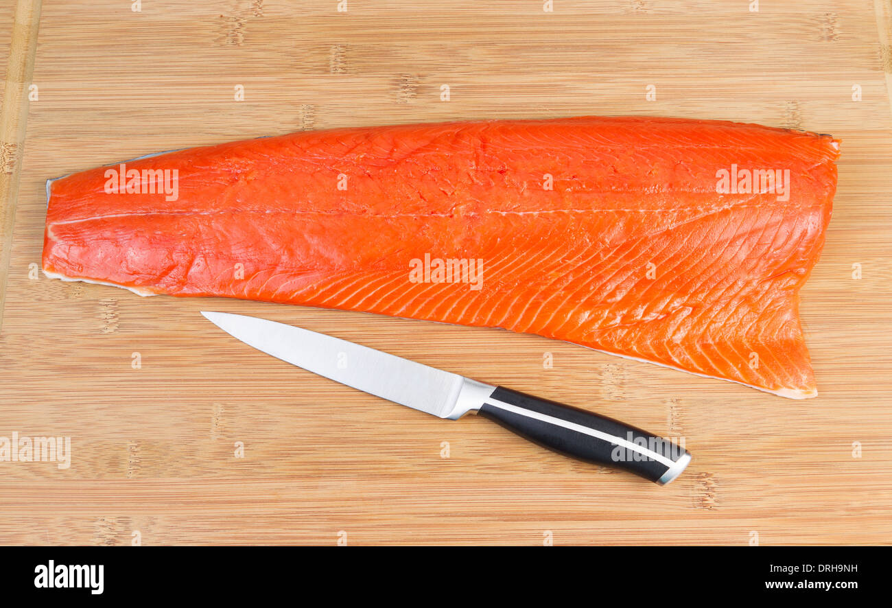 Horizontal photo of fresh Wild Red Salmon with sharp cutting knife on