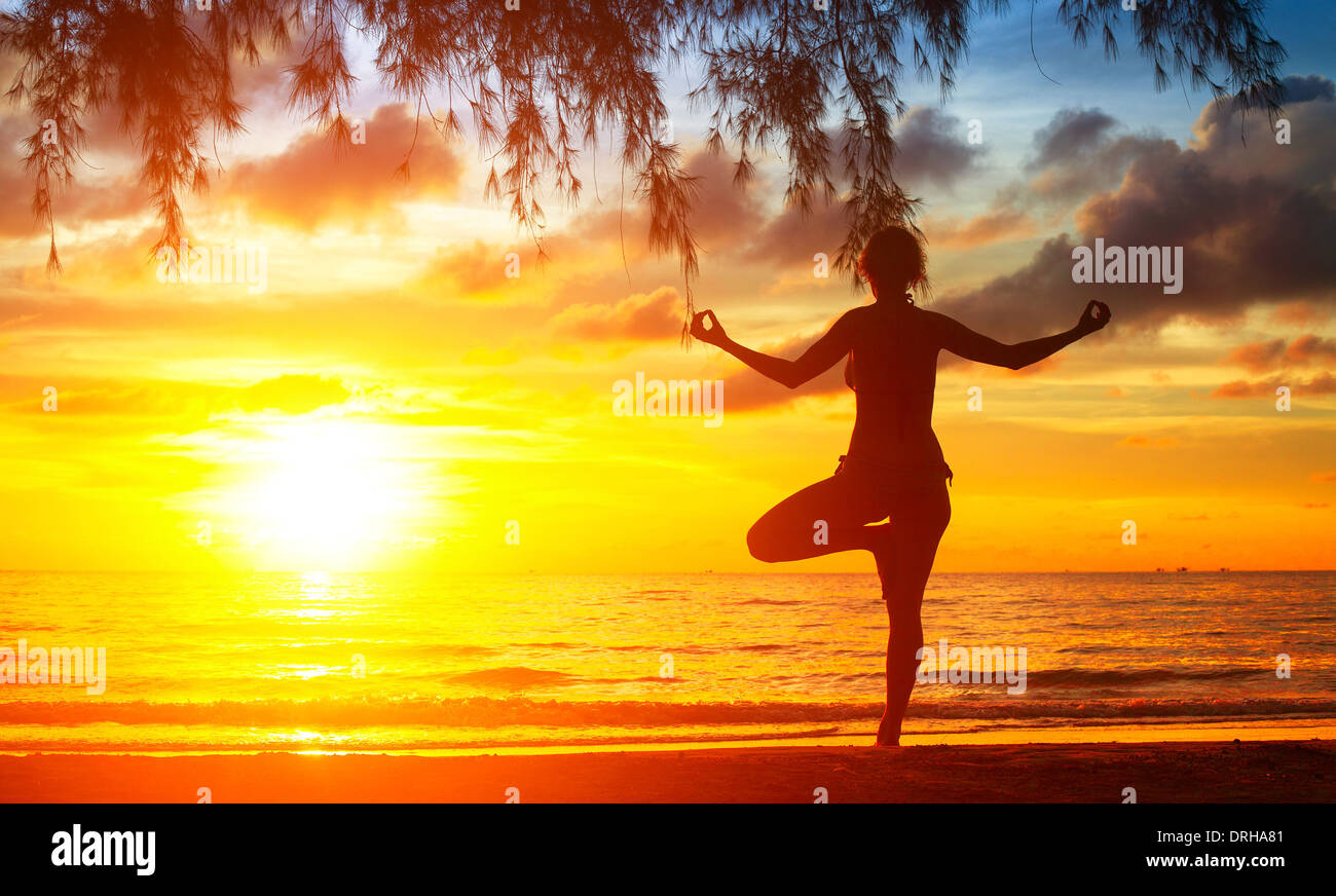 Silhouette of woman meditating on the beach. Yoga and fitness Stock ...