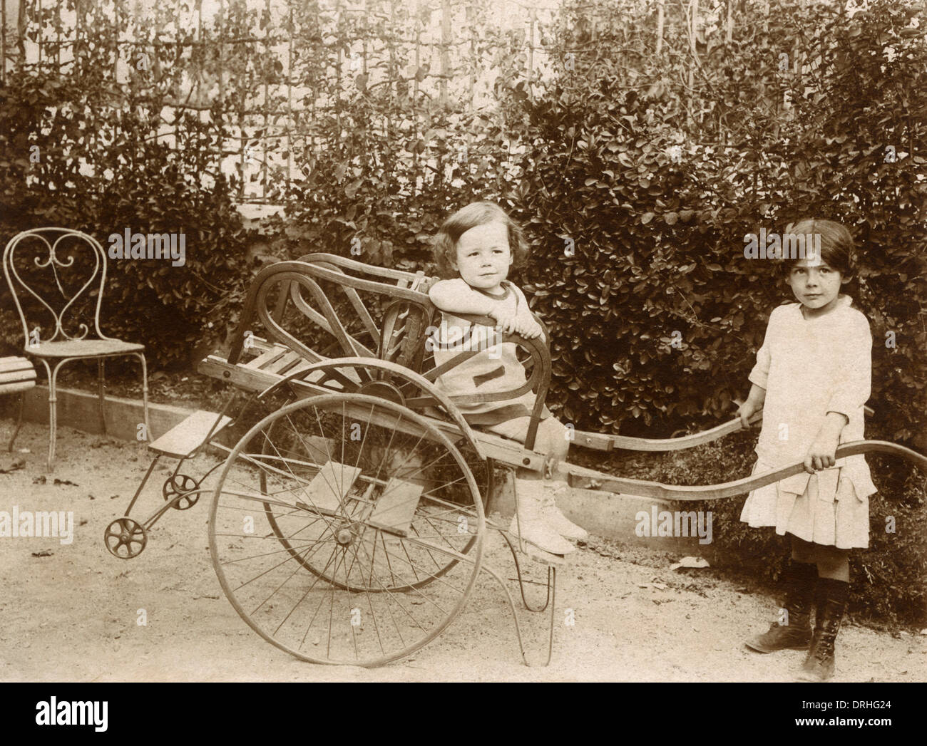 Two girls playing with a push cart Stock Photo
