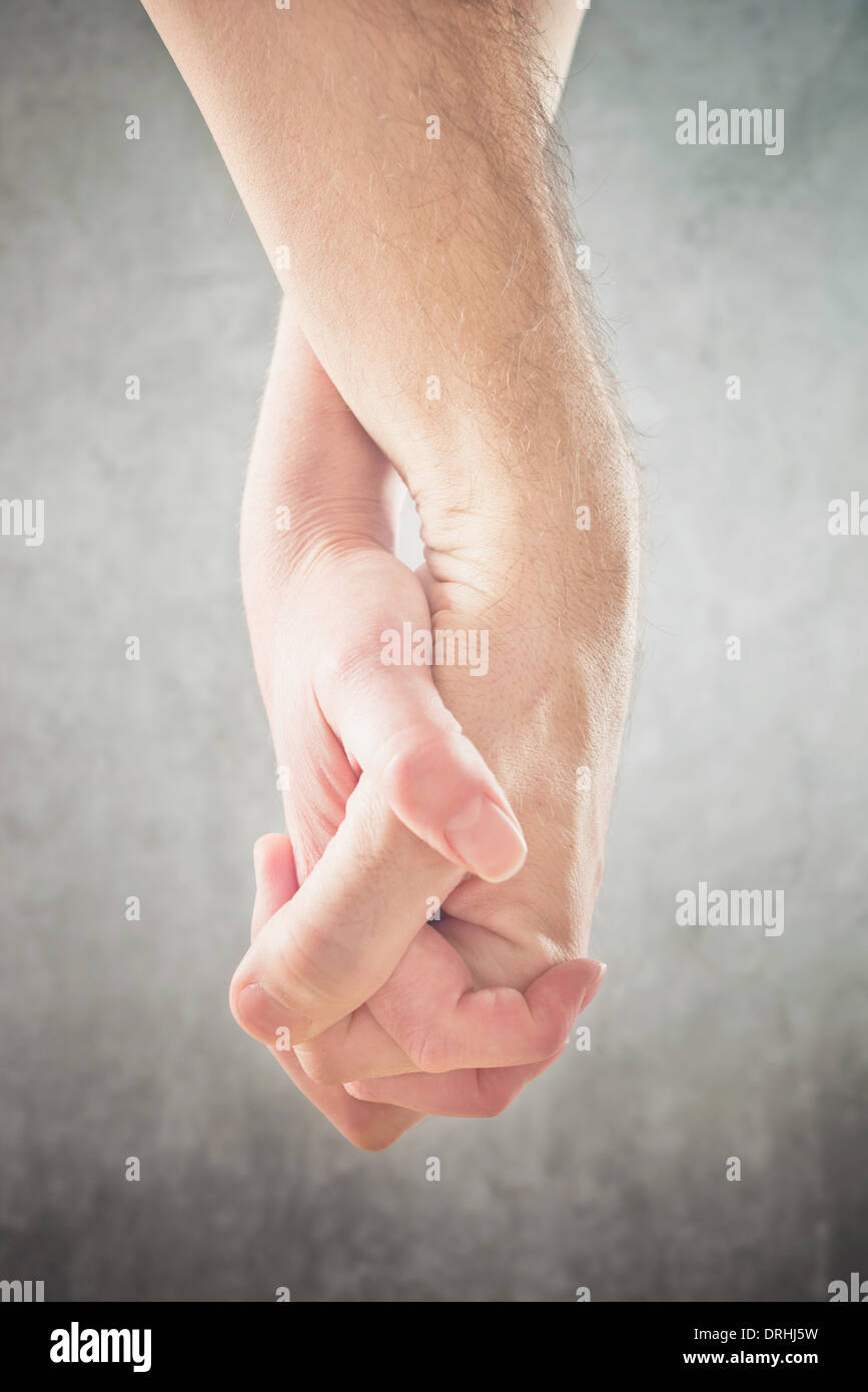 Couple holding hands. Man and woman holding hands, close up. Stock Photo