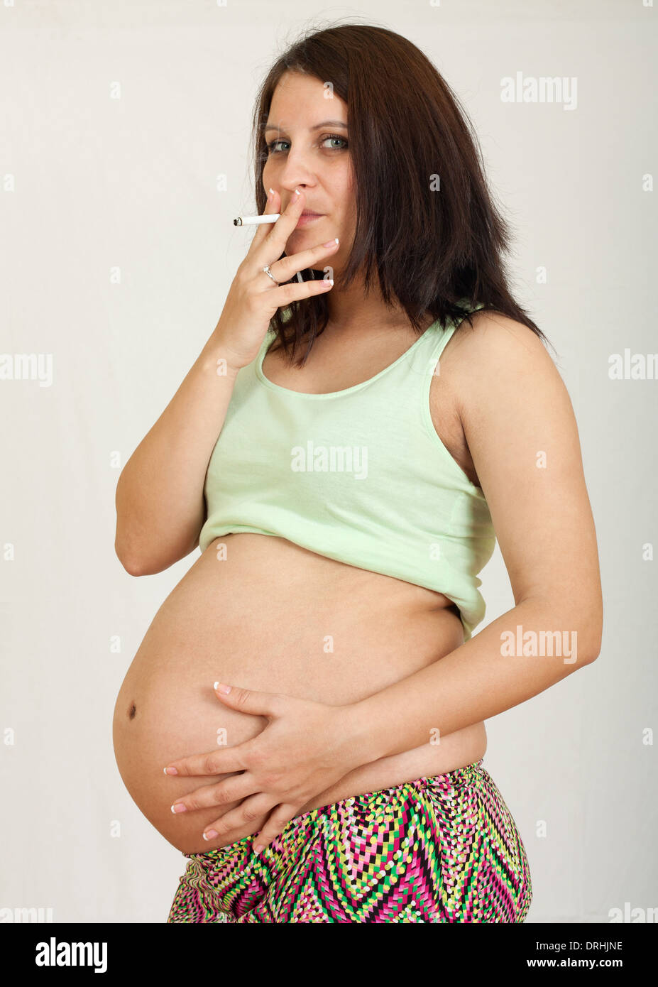 Pregnant woman smoking cigarette.Unhealthy smoker concept Stock Photo