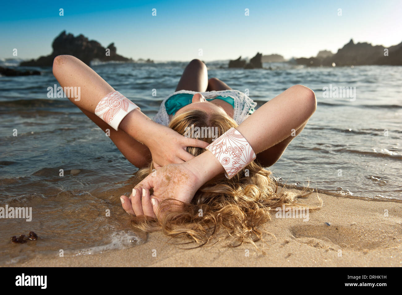 Gorgeous blond model in bikini on beach with beautiful accessories. Stock Photo
