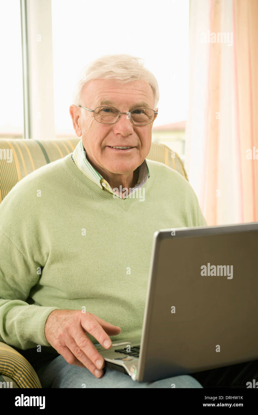 Senior man using laptop in nursing home, Bavaria, Germany Stock Photo