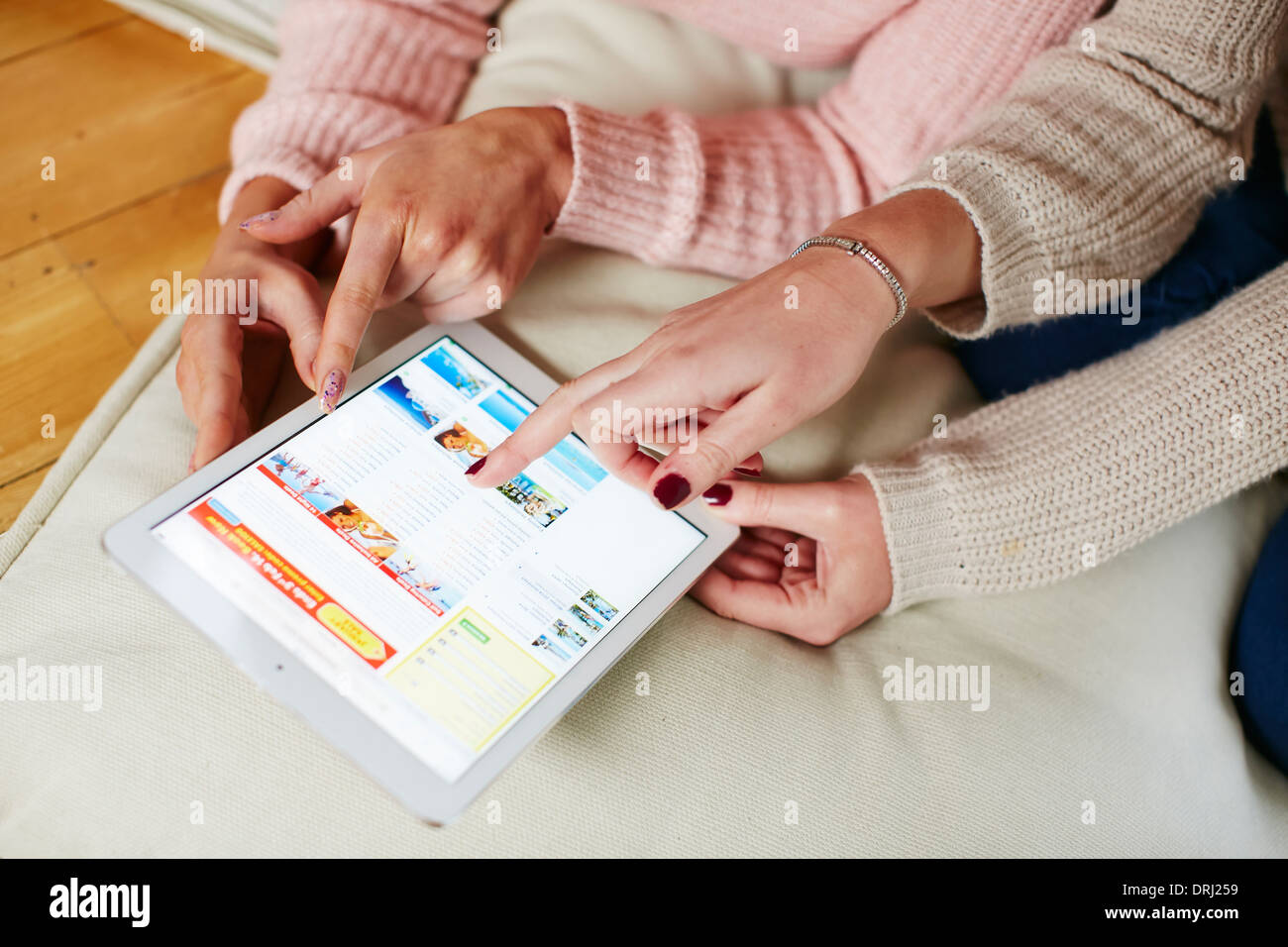 Girls looking at booking a holiday online Stock Photo