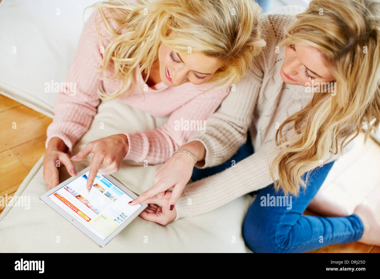 Girls looking at booking a holiday online Stock Photo