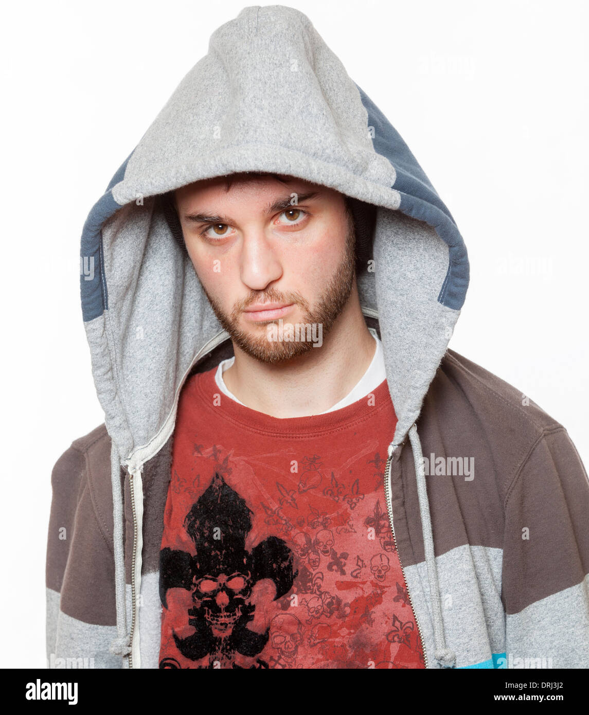 A young man dressed with a hoodie, poses as a gangster. Stock Photo