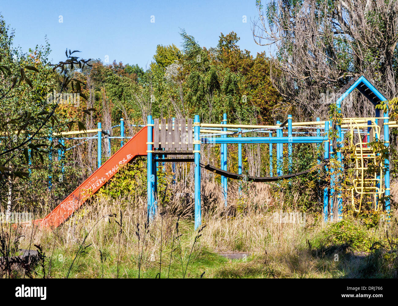 Weed covered climbing frame and slide of children's park at the abandoned Spreepark, Plånterwald, Treptow-Kopernick, Berlin Stock Photo