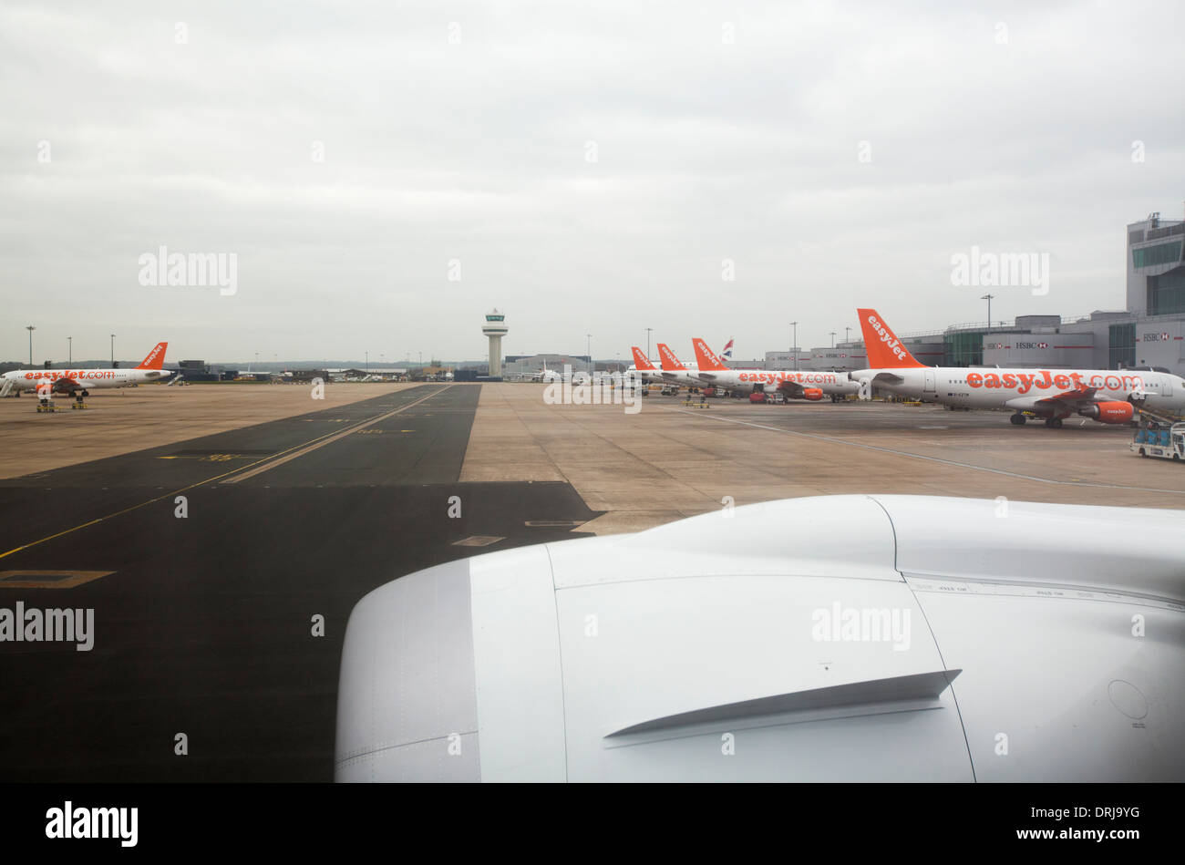 View of Gatwick Airport North terminal showing row of parked Easyjet aircraft plane Stock Photo